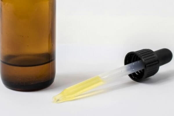 Castor oil in amber glass bottle and glass dropper